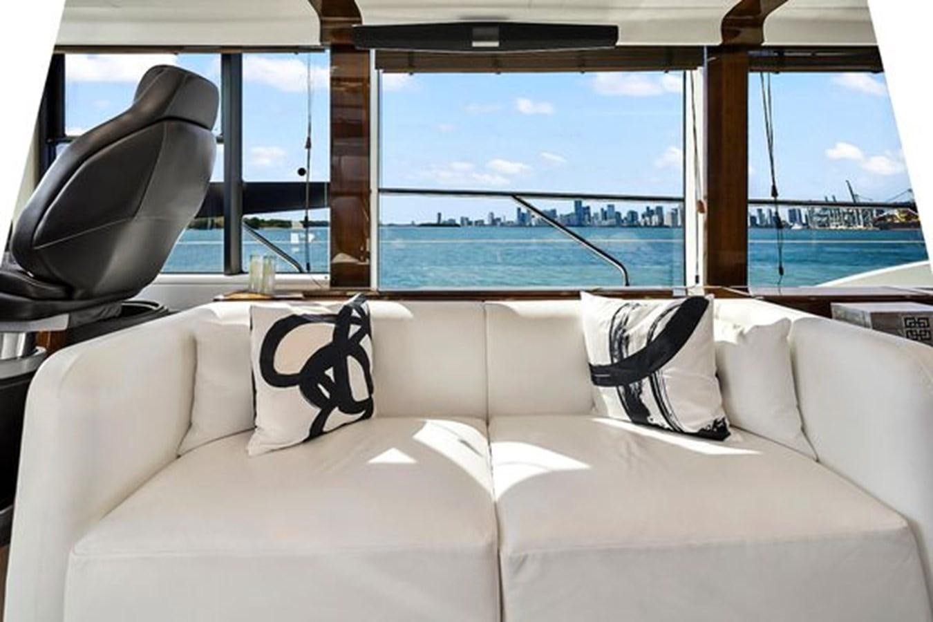 a couch with pillows in front of a window aboard 2021 FAIRLINE SQUADRON 68 Yacht for Sale