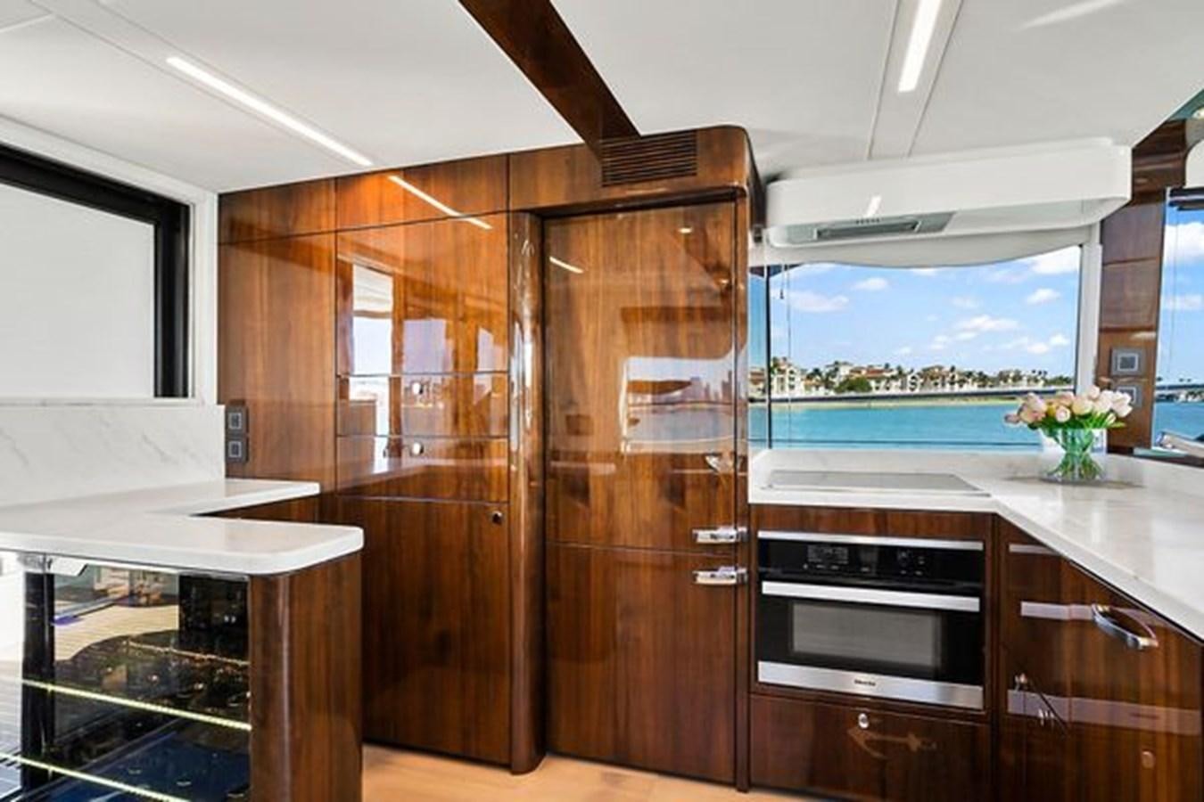 a kitchen with wooden cabinets aboard 2021 FAIRLINE SQUADRON 68 Yacht for Sale