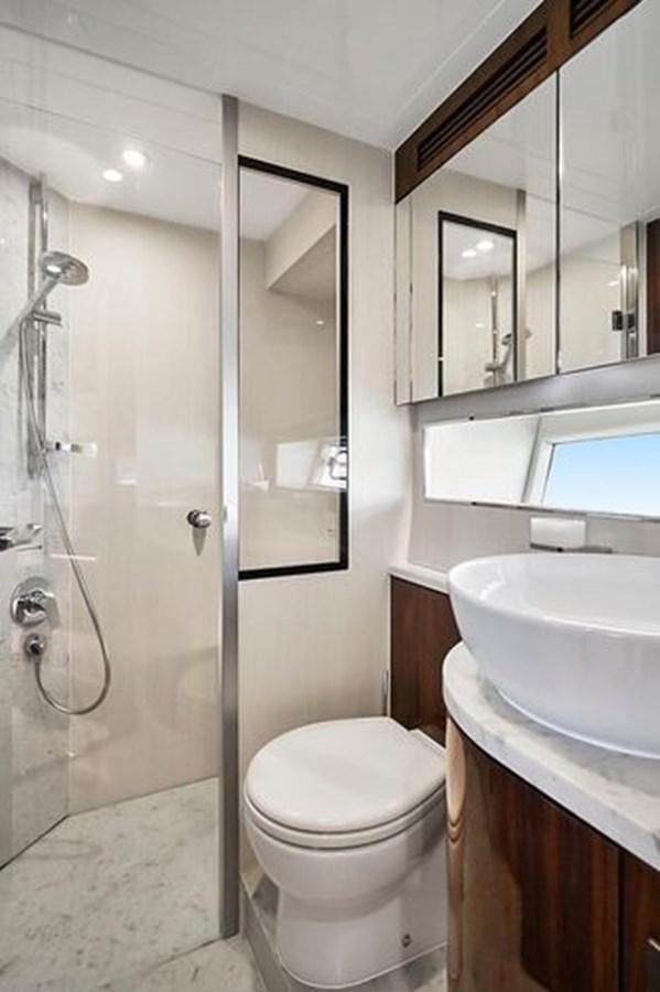 a bathroom with a toilet and sink aboard 2021 FAIRLINE SQUADRON 68 Yacht for Sale