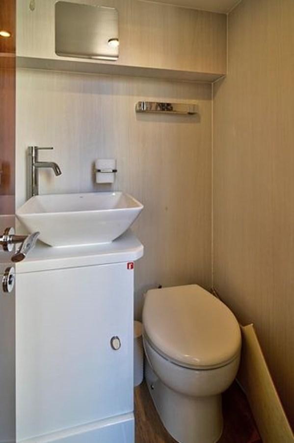 a small bathroom with a toilet and sink aboard 2021 FAIRLINE SQUADRON 68 Yacht for Sale