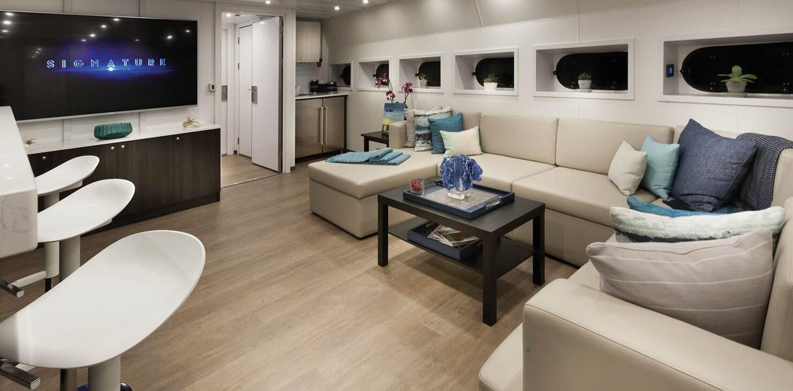 a living room with a large screen aboard AXIS Yacht for Sale