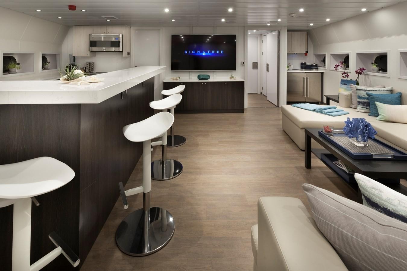 a room with a tv and tables aboard AXIS Yacht for Sale