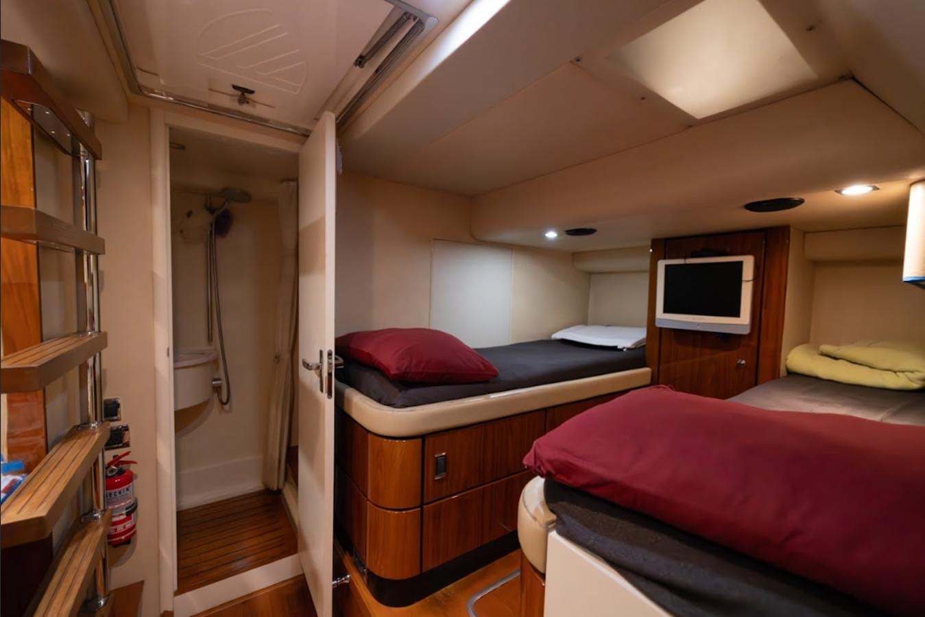 a bedroom with a bed and a tv aboard FAIRLINE SQUADRON 70 - 2010 Yacht for Sale