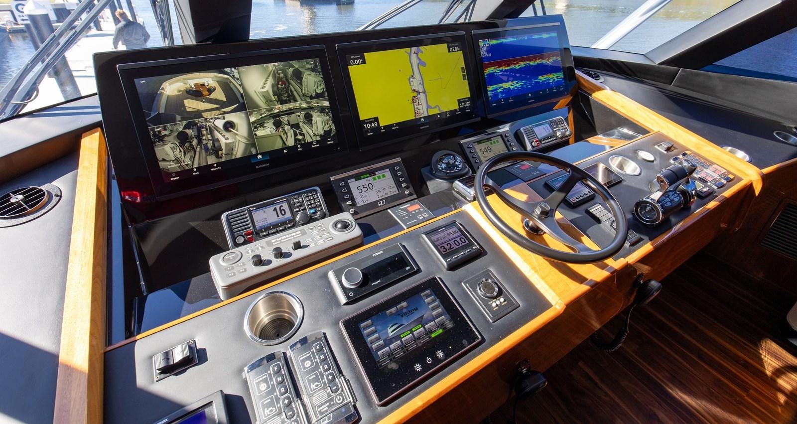 a yellow console with a screen and buttons and a game console aboard TEAM HARVEY Yacht for Sale