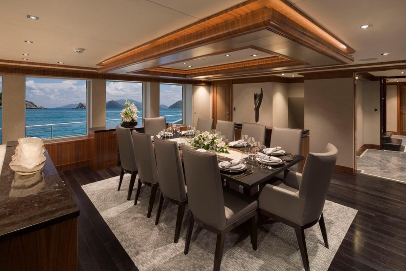 a dining room with a large table and chairs aboard MUCHOS MAS Yacht for Sale