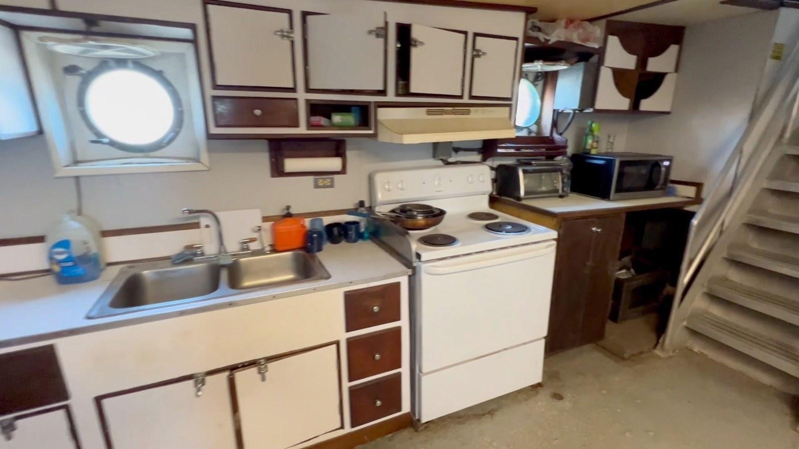 a kitchen with white cabinets aboard COMMERCIAL Yacht for Sale