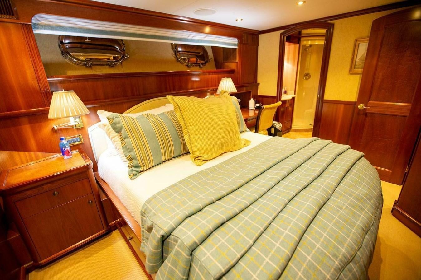 a bed with a green and yellow comforter aboard WATERFORD Yacht for Sale