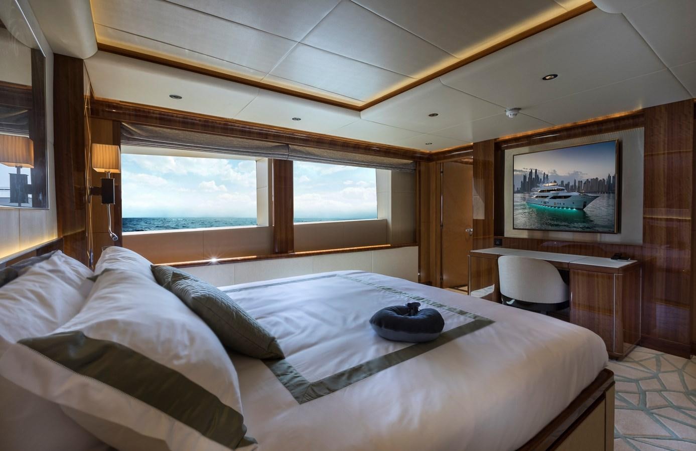 a bed with a white sheet and a television on the wall aboard SEHAMIA Yacht for Sale