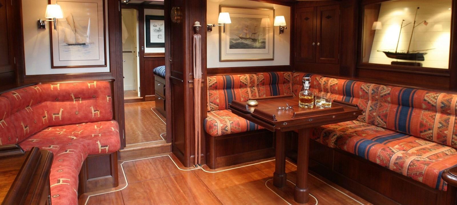 a living room with a table and couches aboard ALDEBARAN Yacht for Sale