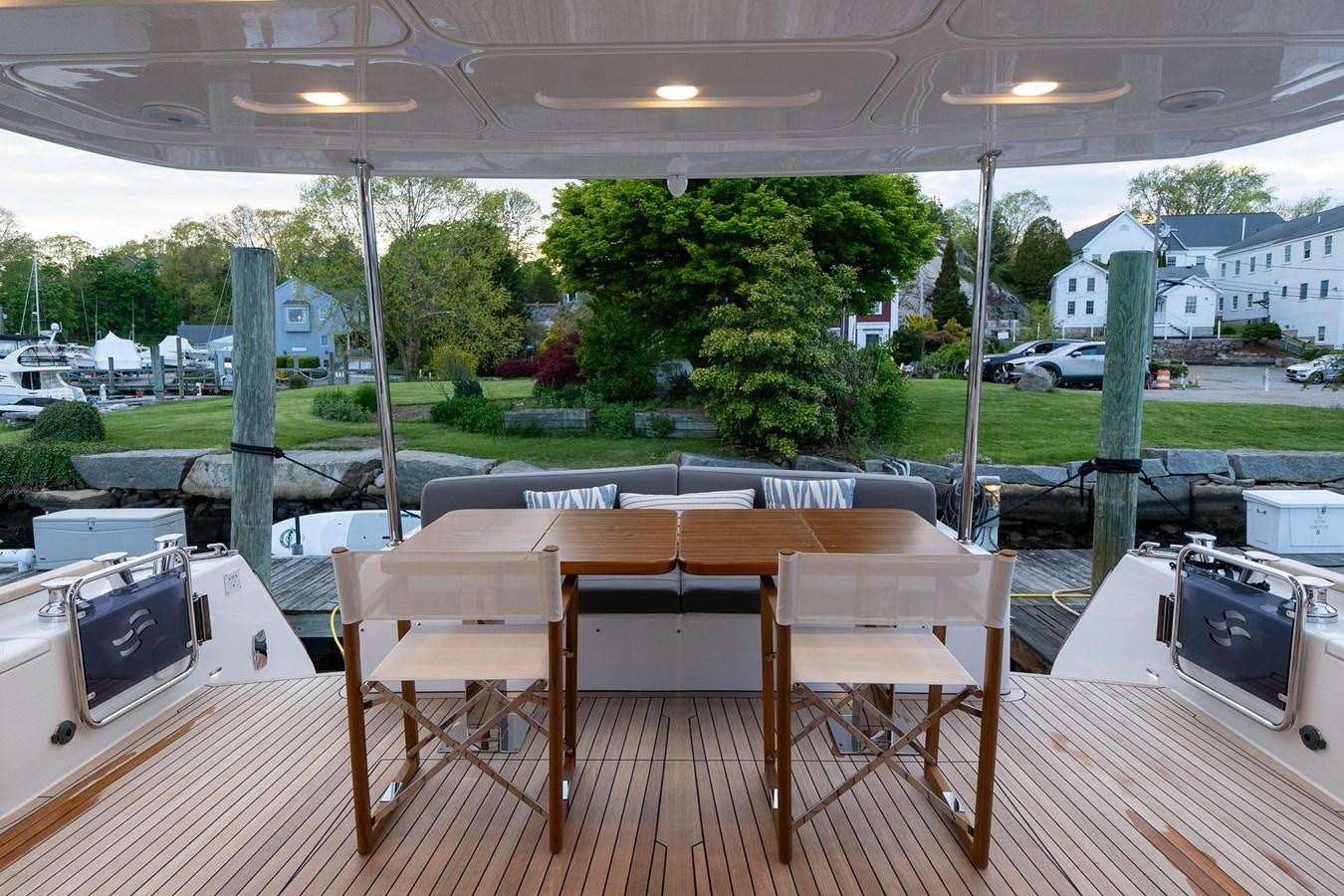 a deck with a table and chairs aboard NEW 2023 SIRENA 68 Yacht for Sale