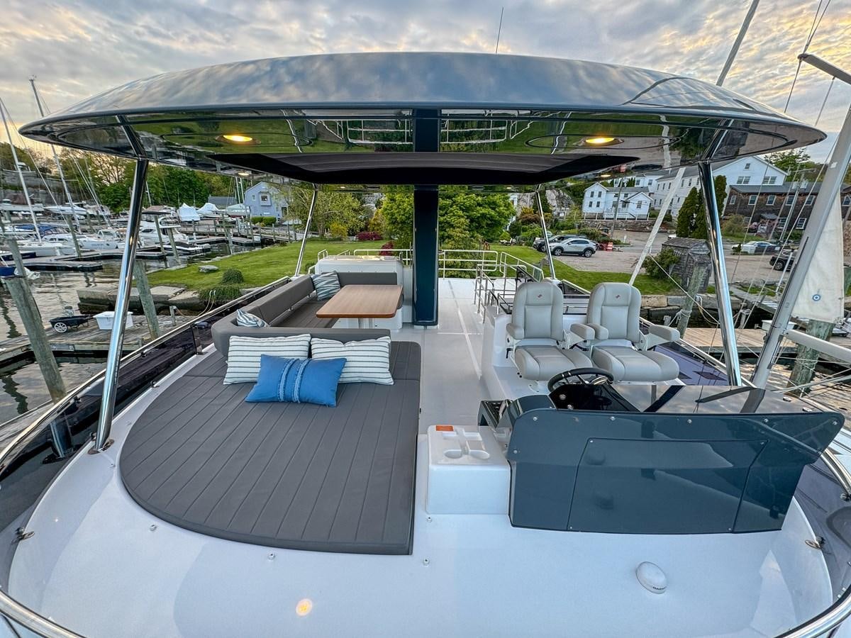 a swimming pool with a deck and chairs and a building in the background aboard NEW 2023 SIRENA 68 Yacht for Sale