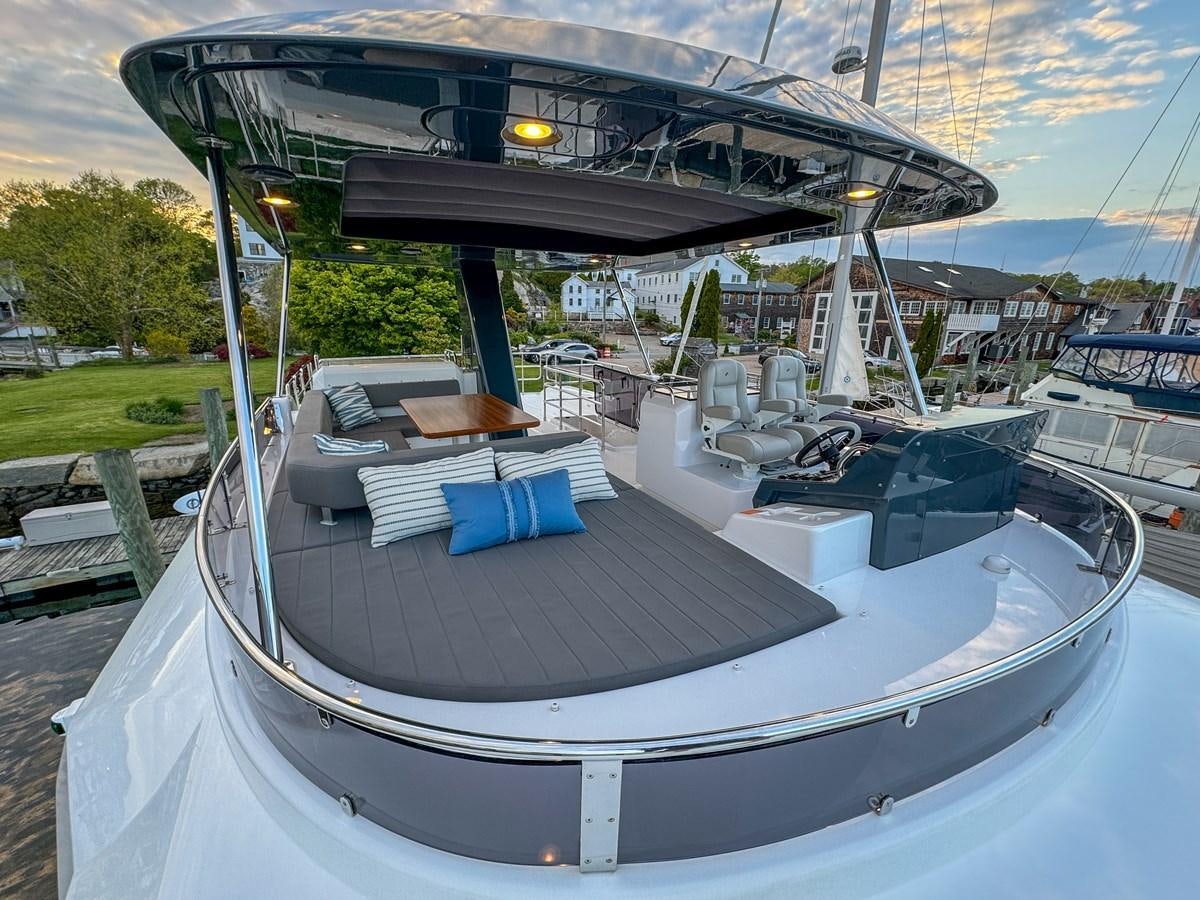 a large white boat with blue seats aboard NEW 2023 SIRENA 68 Yacht for Sale