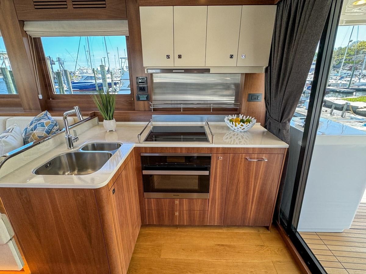 a kitchen with wooden cabinets aboard NEW 2023 SIRENA 68 Yacht for Sale