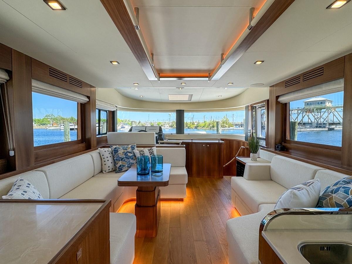 a living room with a large window aboard NEW 2023 SIRENA 68 Yacht for Sale