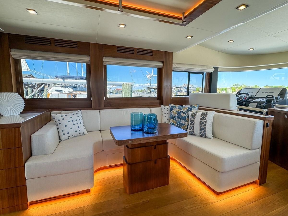 a living room with a table and couches aboard NEW 2023 SIRENA 68 Yacht for Sale