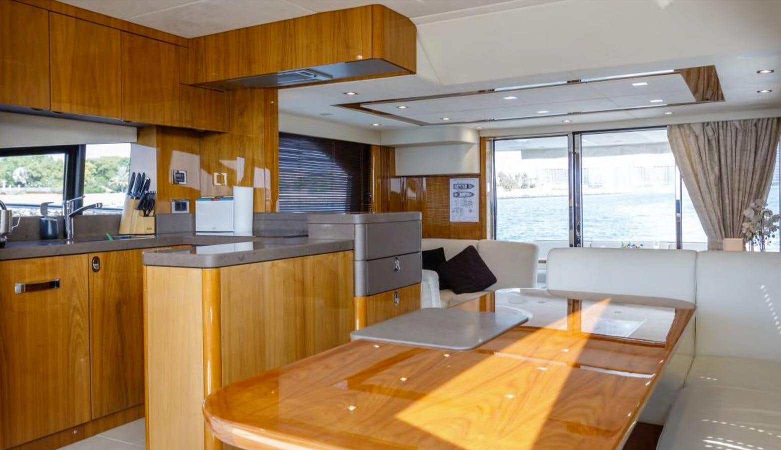 a kitchen with a table and a couch aboard RAIDEX Yacht for Sale