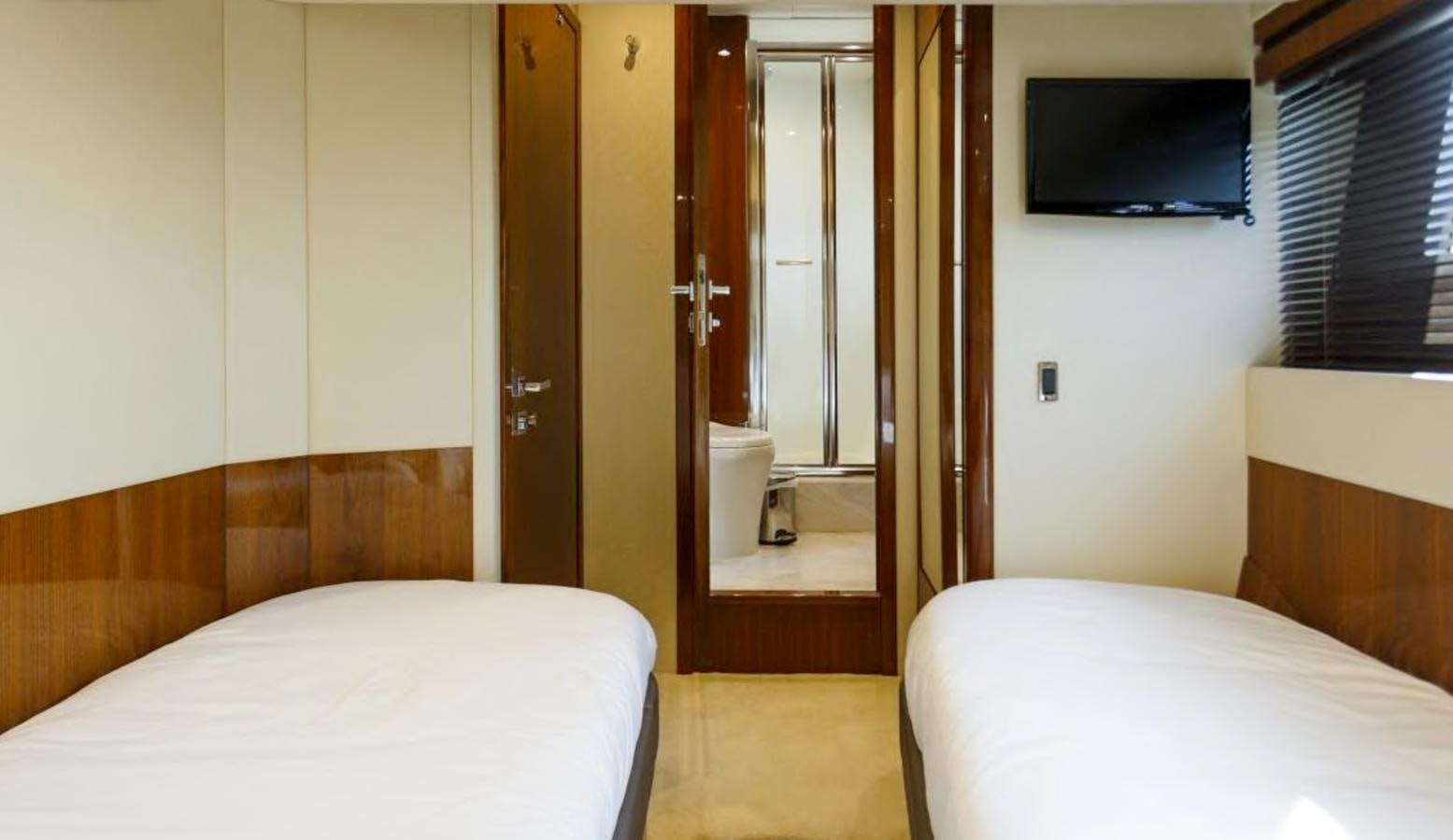 a bedroom with a bed and a television aboard RAIDEX Yacht for Sale