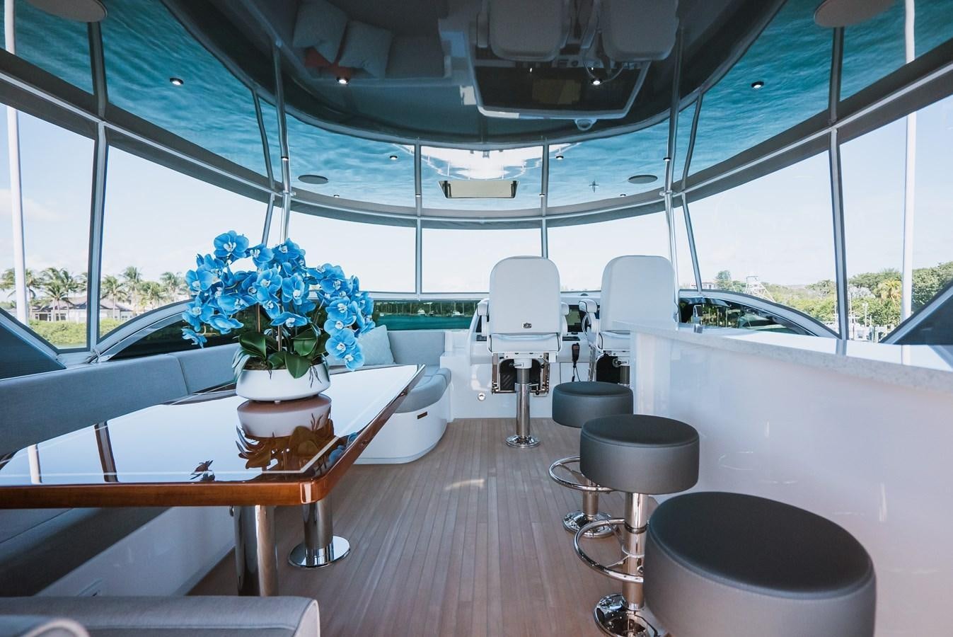 a room with a table chairs and a plant in it aboard LATITUDES Yacht for Sale
