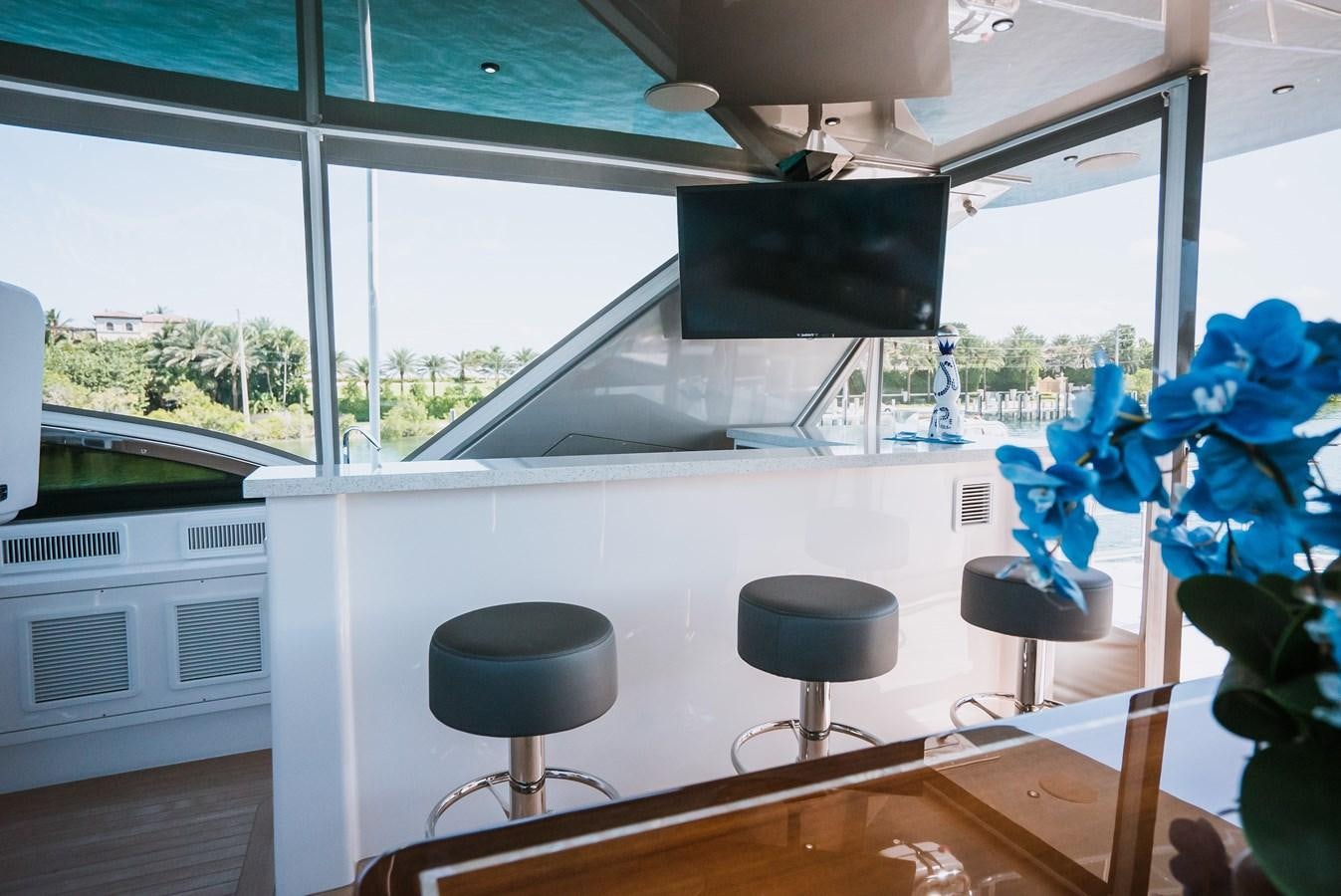 a room with a couple of stools and a television aboard LATITUDES Yacht for Sale