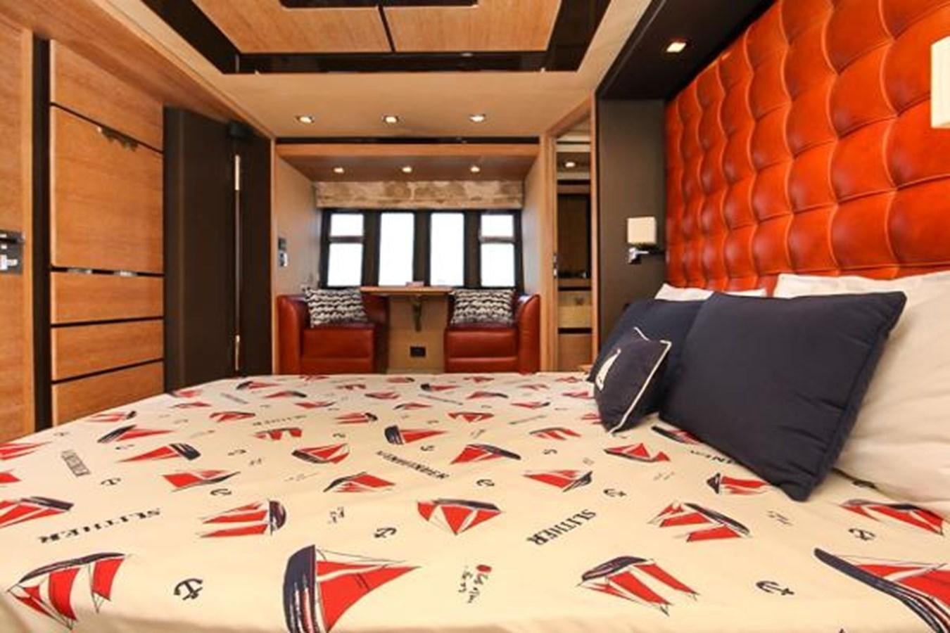 a bed with a white sheet and pillows in a room with a wood door and a window with aboard 70 Yacht for Sale