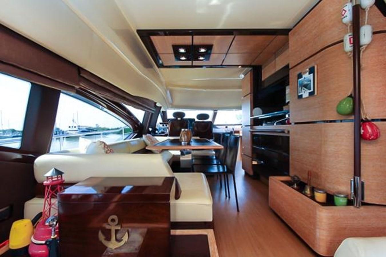a room with a couch and a table and a shelf with objects on it aboard 70 Yacht for Sale