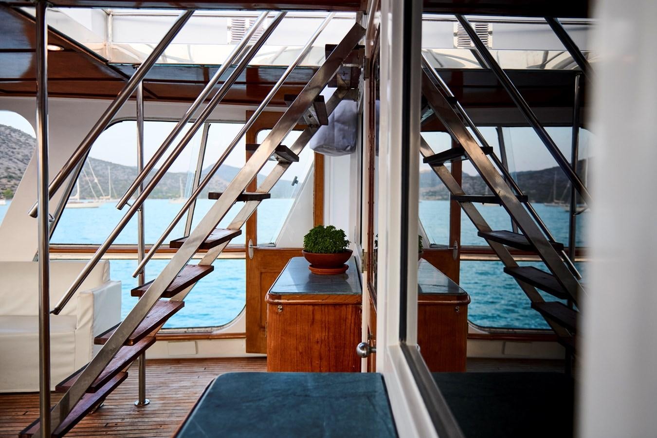 a room with a large window and a railing with a railing and a pool and a plant on aboard PRINCESS SOFIA Yacht for Sale