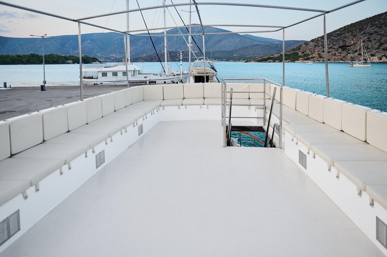 a white building with a white wall and a railing next to a body of water aboard PRINCESS SOFIA Yacht for Sale