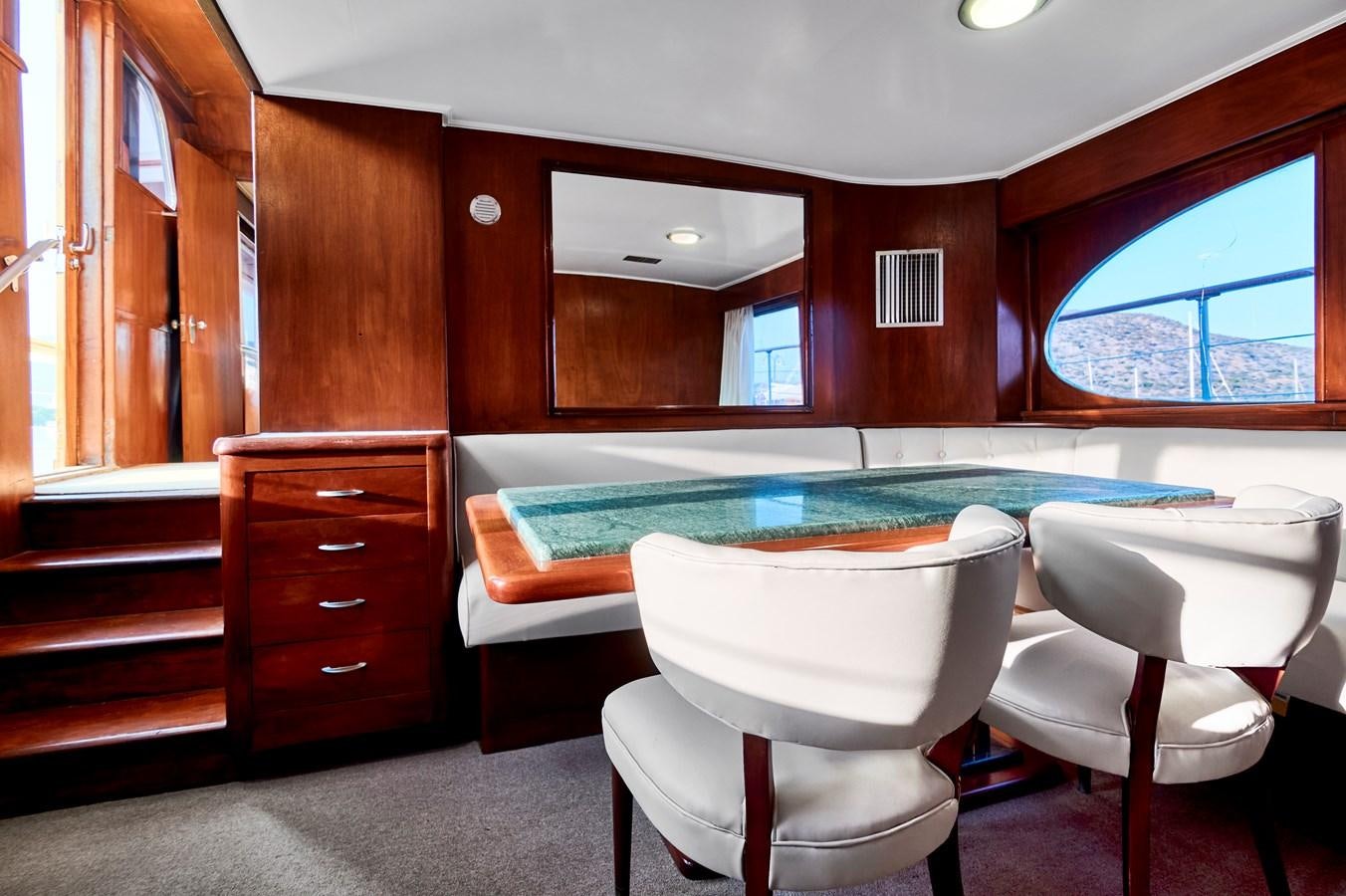 a pool table and chairs in a room with a wood cabinet and a window aboard PRINCESS SOFIA Yacht for Sale