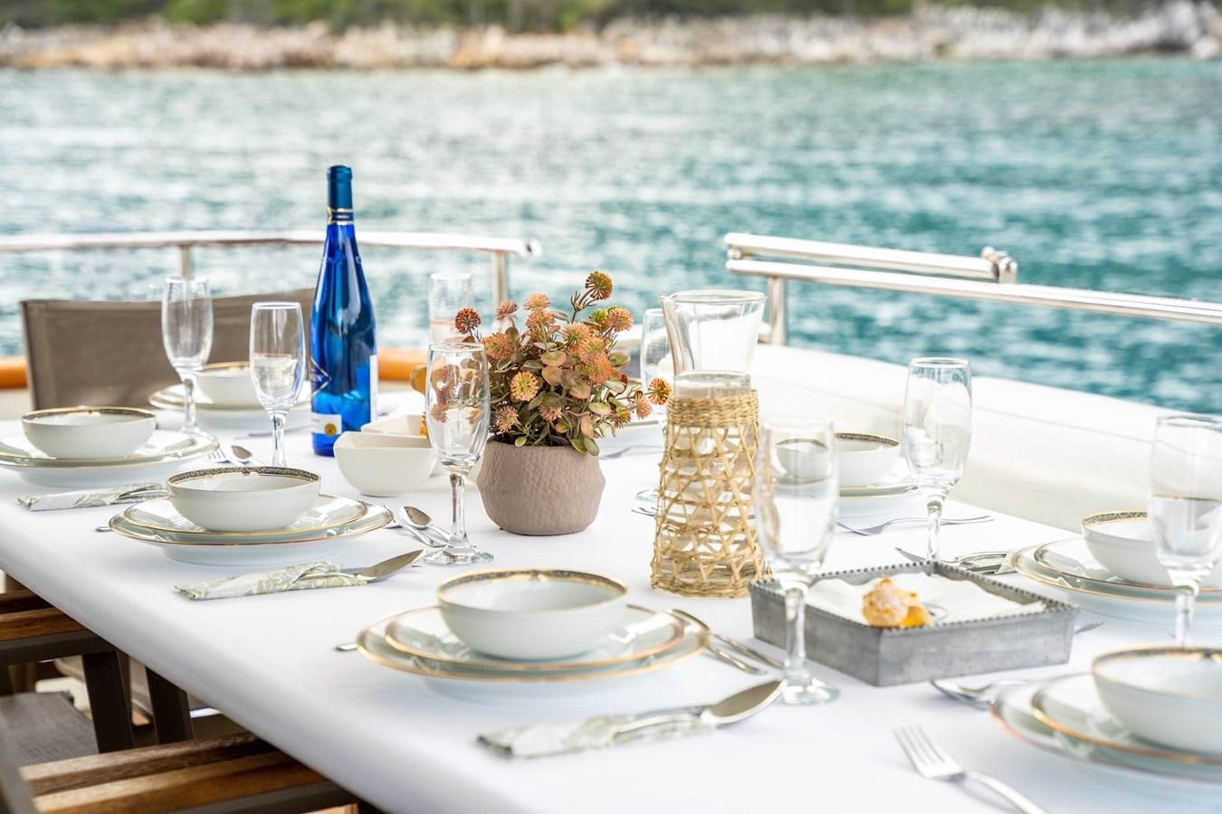 a table set with food and wine aboard D FLAWLESS Yacht for Sale