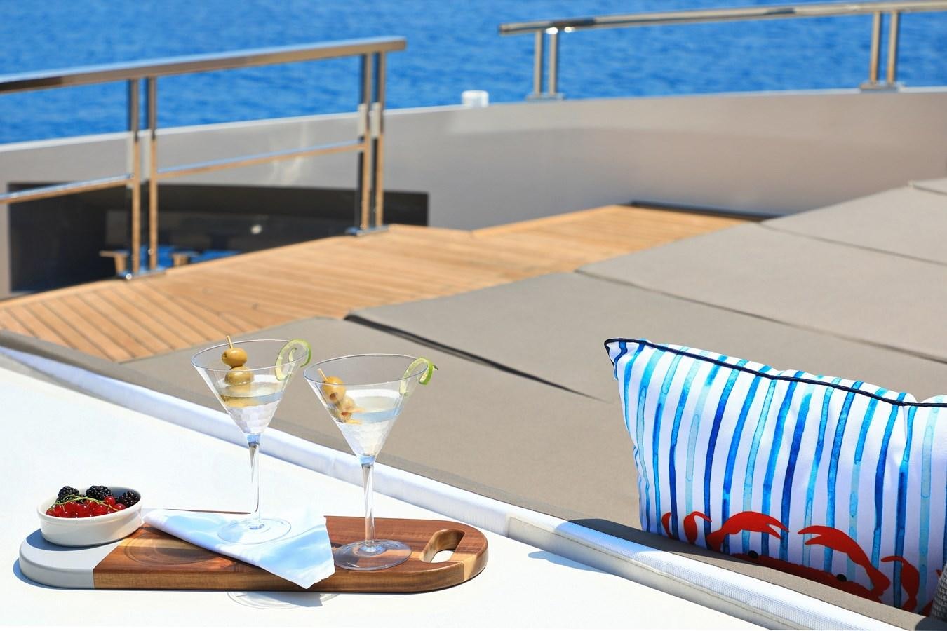a table with glasses and a bowl of fruit on it aboard TORTURA Yacht for Sale