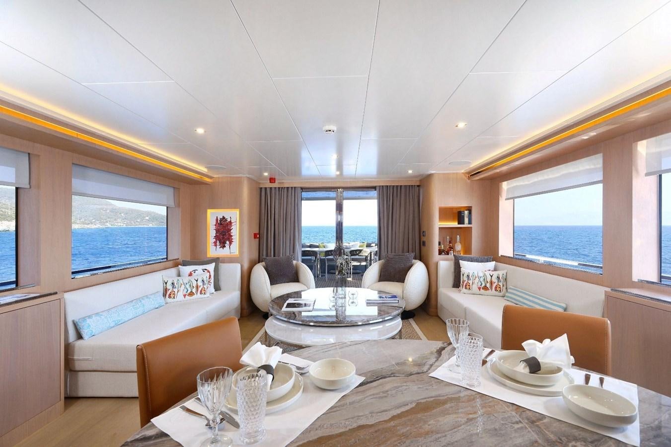 a large living room with a large table and chairs aboard TORTURA Yacht for Sale