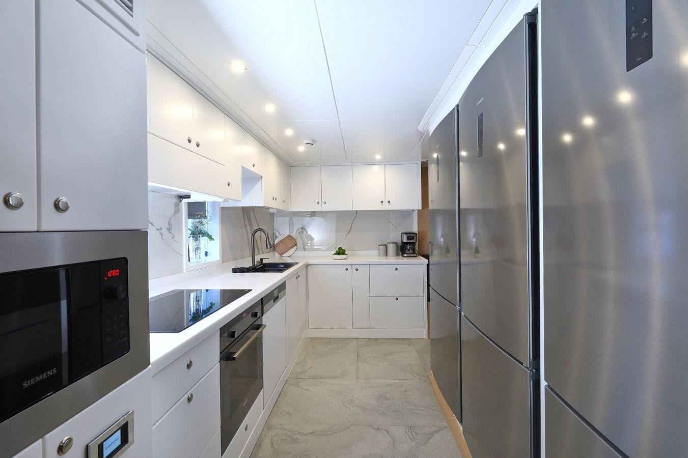 a kitchen with white cabinets aboard TORTURA Yacht for Sale