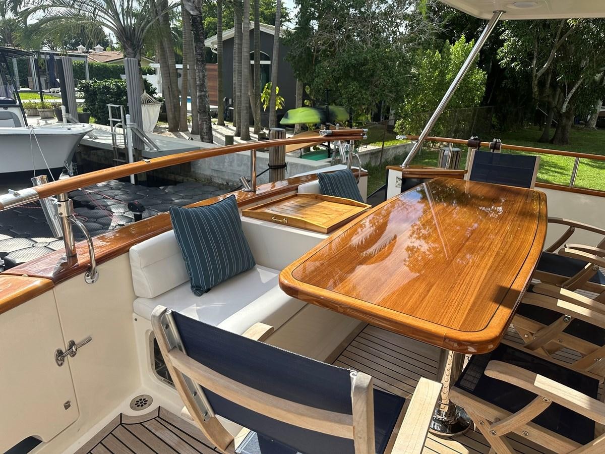 a deck with a table and chairs aboard BANDOL Yacht for Sale