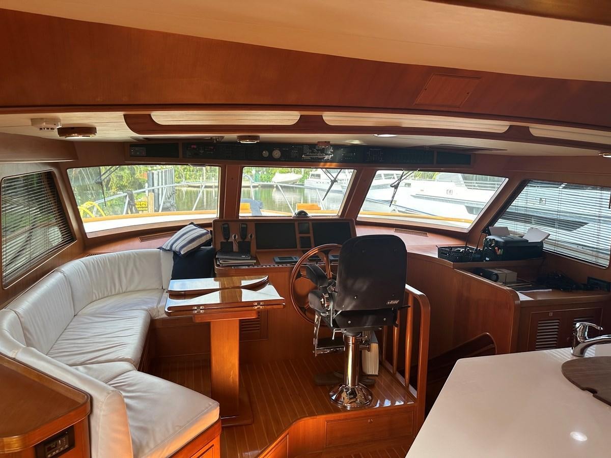 inside of a vehicle with tables and chairs and a bench aboard BANDOL Yacht for Sale