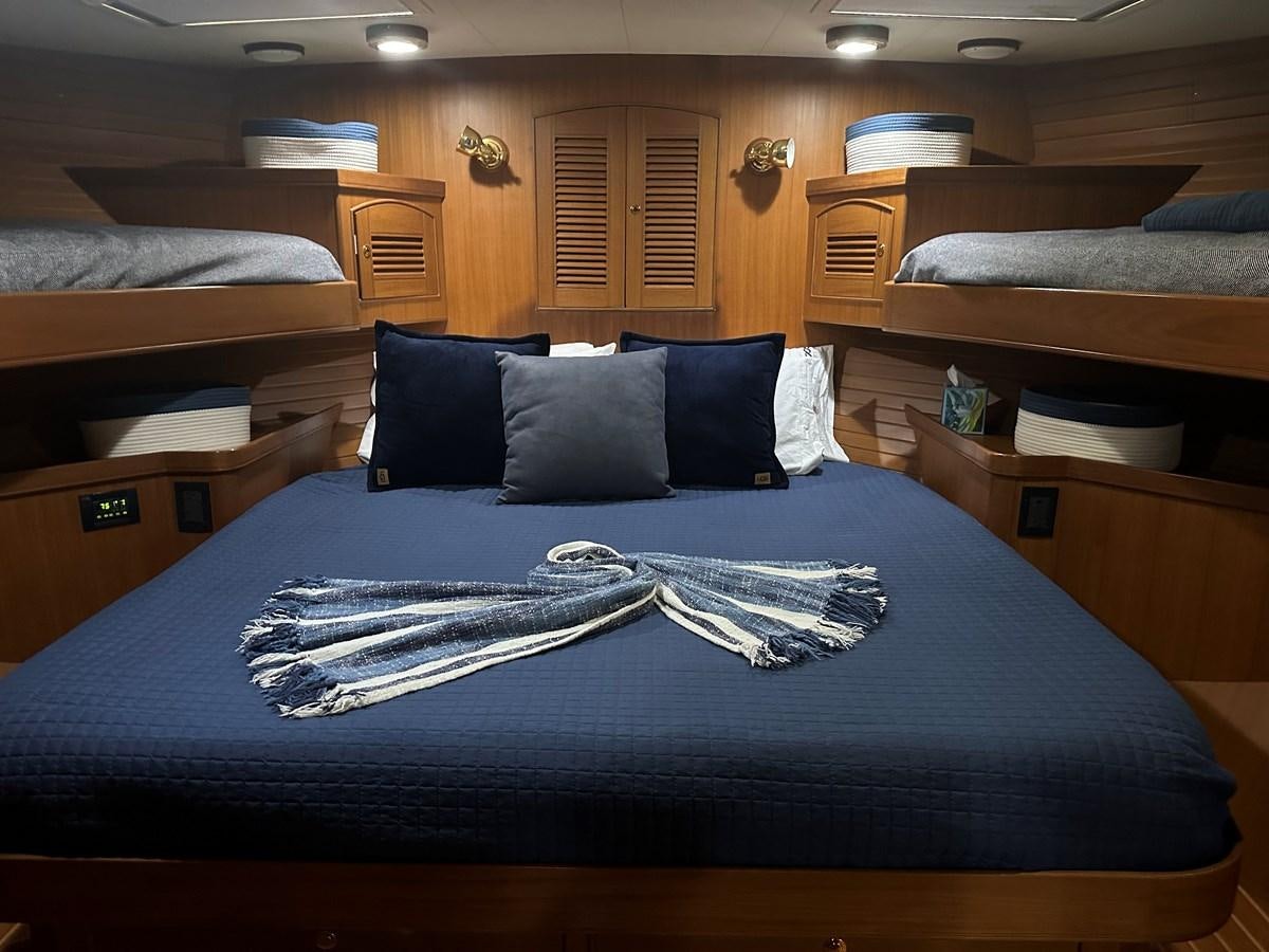 a bed with a blue comforter aboard BANDOL Yacht for Sale