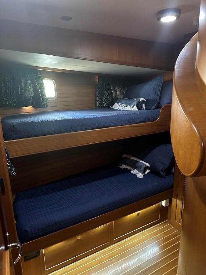 a bed with blue sheets aboard BANDOL Yacht for Sale