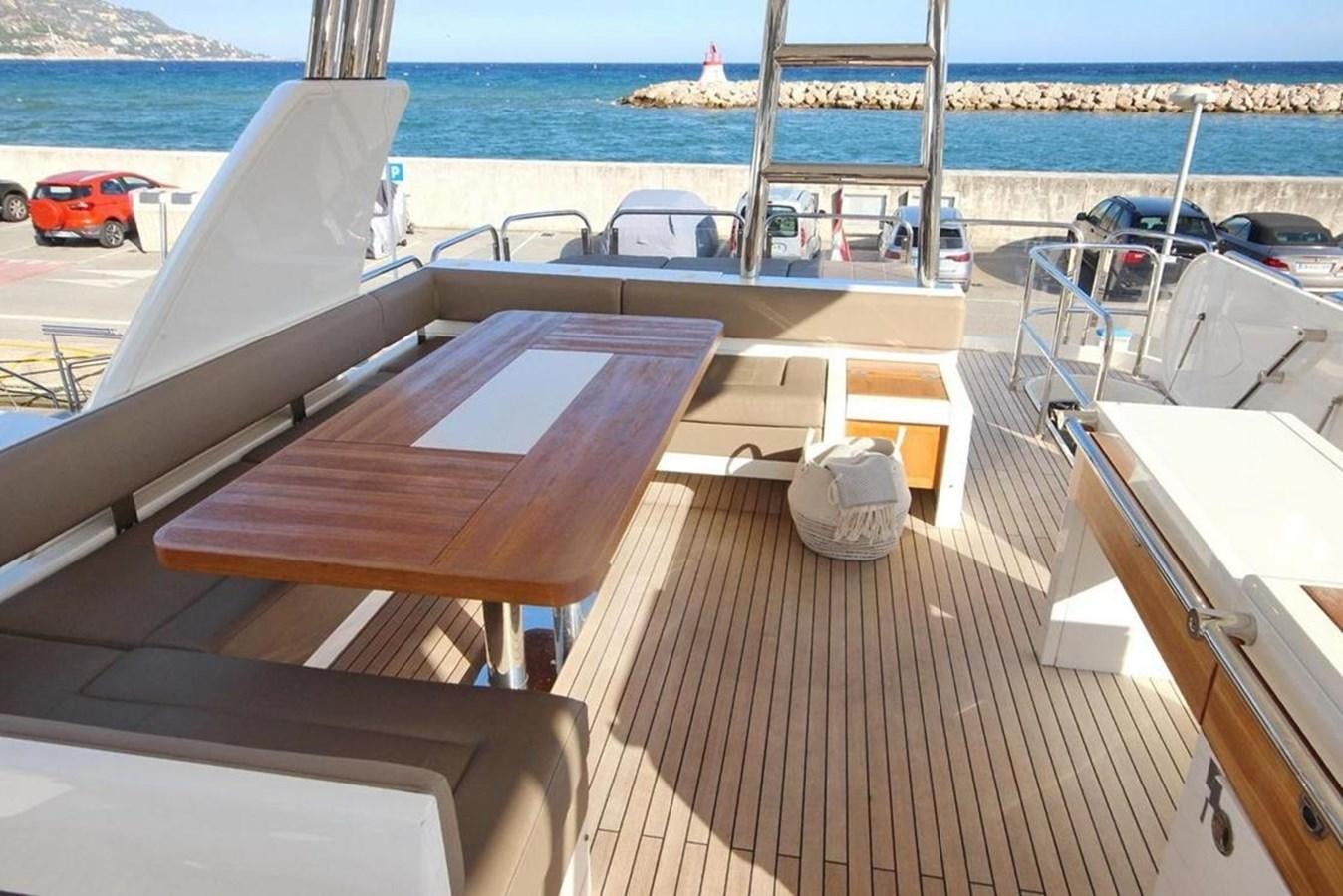 a deck with a boat and a body of water in the background aboard SQUADRON 80 Yacht for Sale