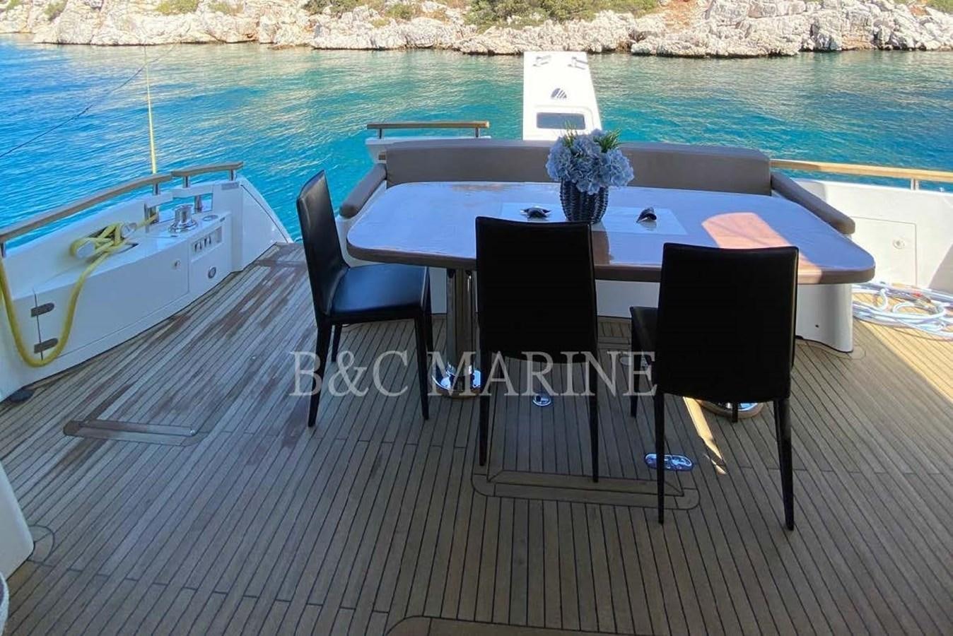 a table and chairs on a deck by a pool aboard SQUADRON 80 Yacht for Sale