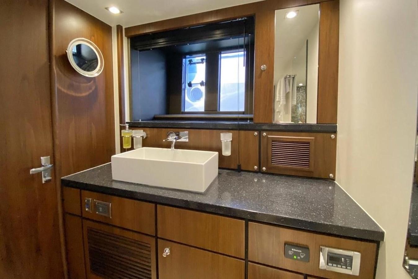 a bathroom with a countertop sink and a large mirror aboard SQUADRON 80 Yacht for Sale