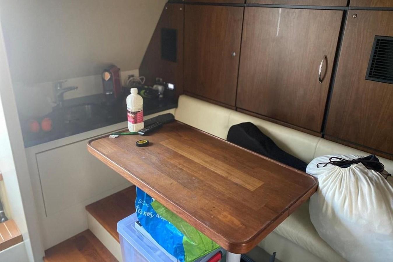 a kitchen with a table and a couch aboard SQUADRON 80 Yacht for Sale
