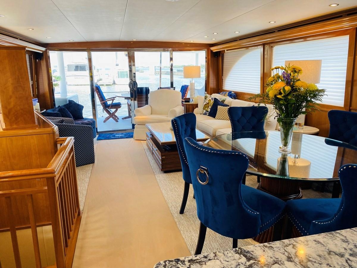 a living room with a blue chair and a table aboard DREAM ON Yacht for Sale