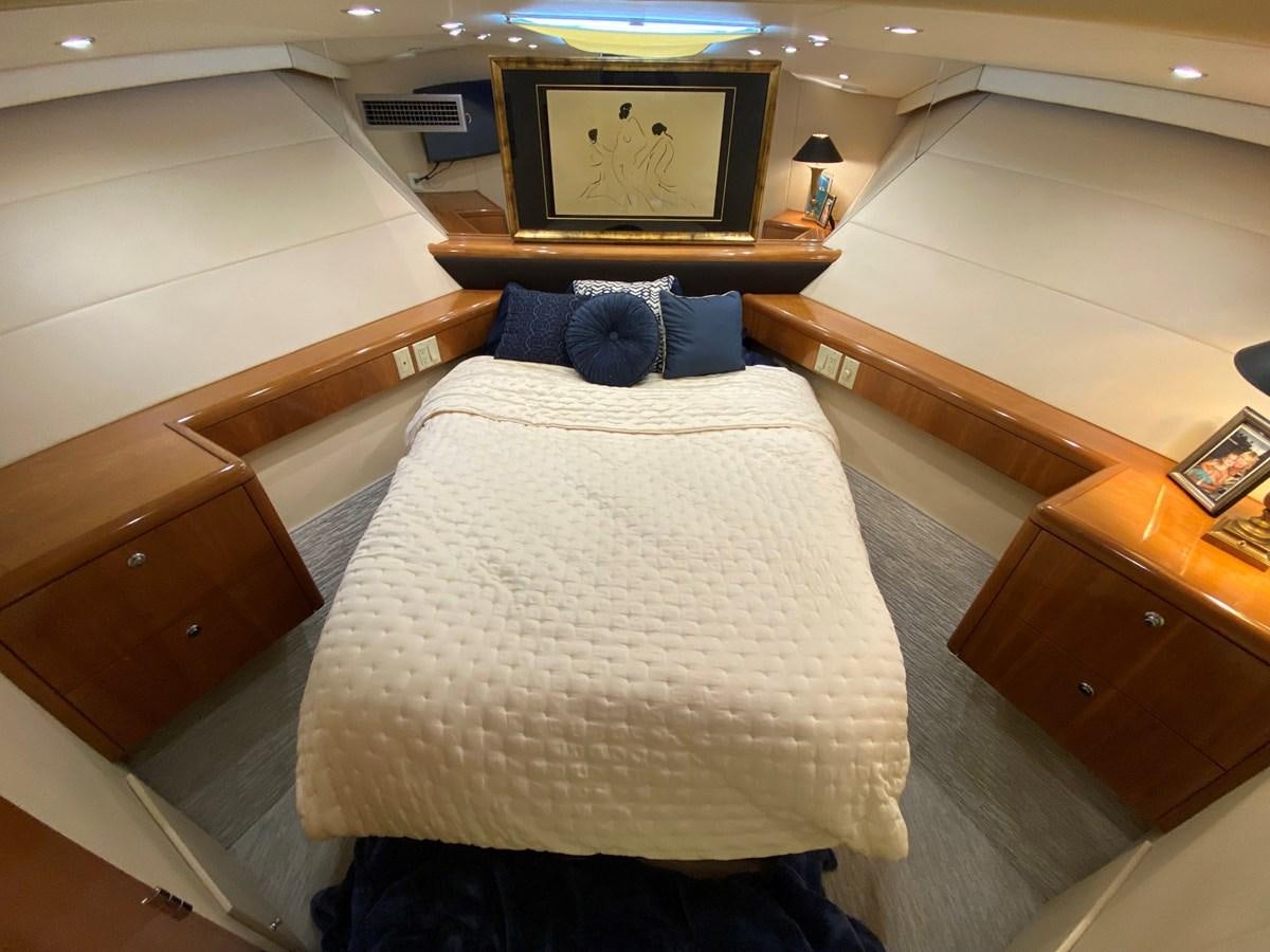 a bed with a white sheet and blue pillow on it aboard DREAM ON Yacht for Sale