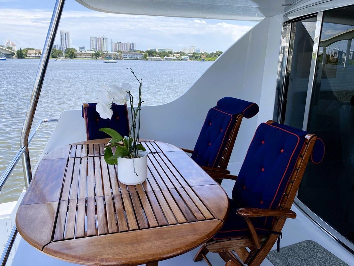 a table with chairs and a plant on it aboard DREAM ON Yacht for Sale