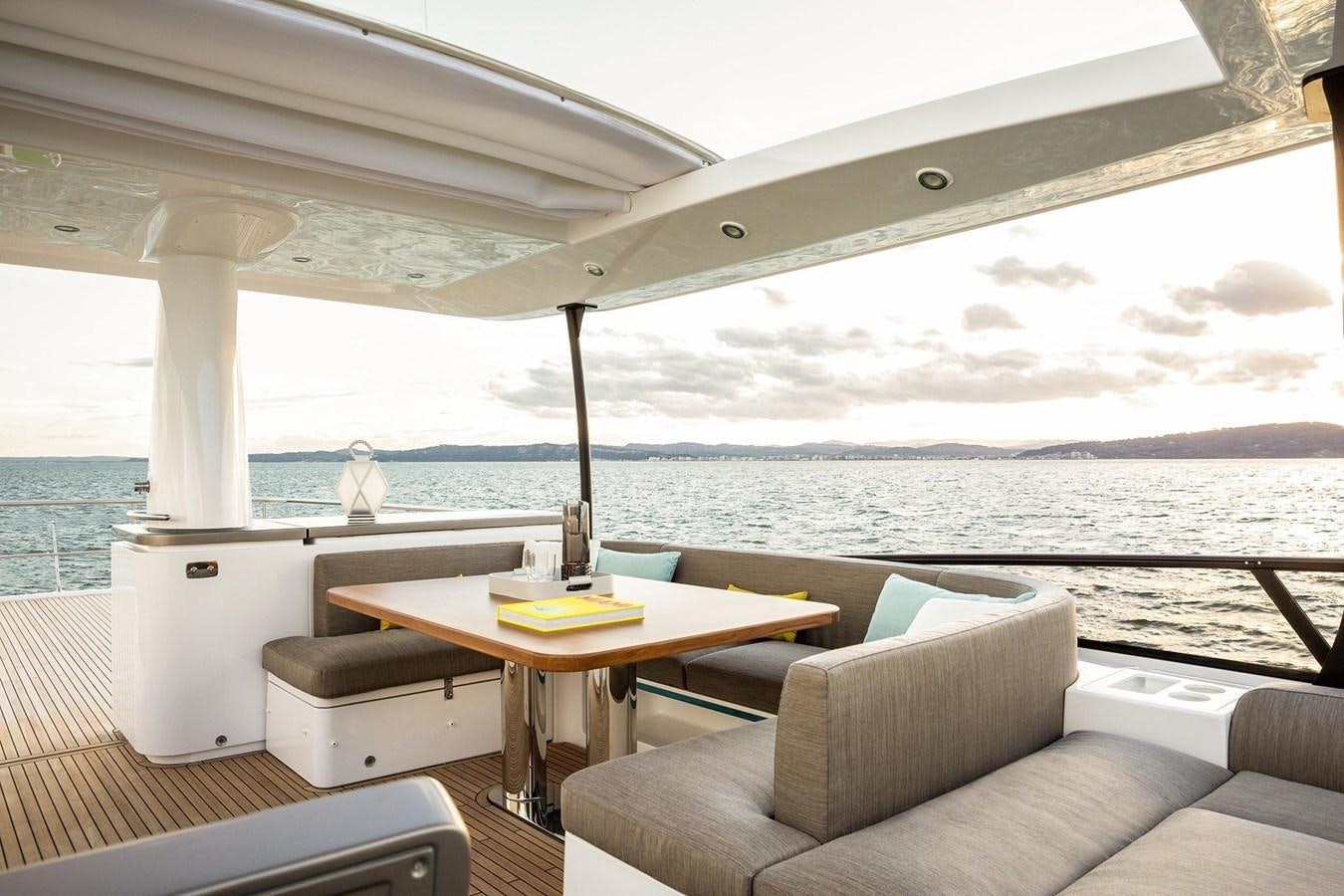 a room with a couch and a table and a view of the ocean aboard AZIMUT MAGELLANO 66 Yacht for Sale