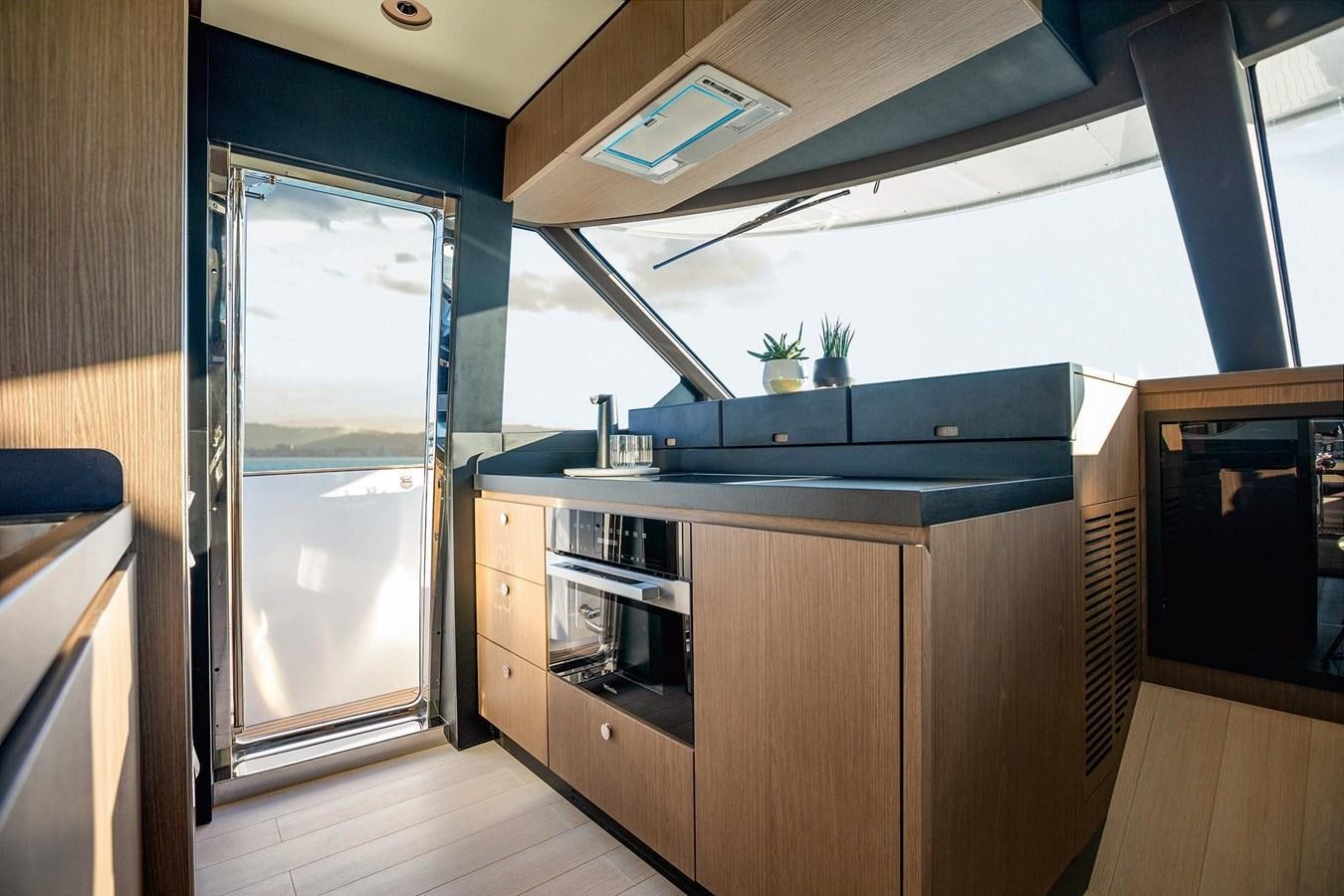 a kitchen with a large window aboard AZIMUT MAGELLANO 66 Yacht for Sale
