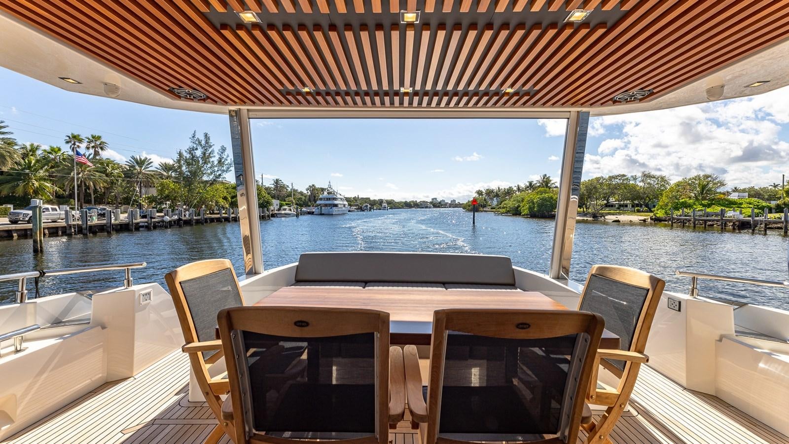 a deck with chairs and tables on it by a body of water aboard ISLA BONITA Yacht for Sale