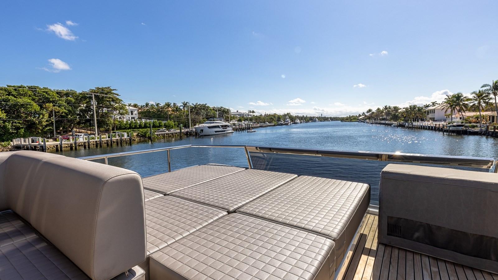 a deck with a pool and a boat in the water aboard ISLA BONITA Yacht for Sale