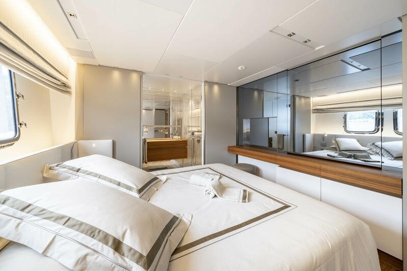 a room with a bed and a desk aboard SALT Yacht for Charter