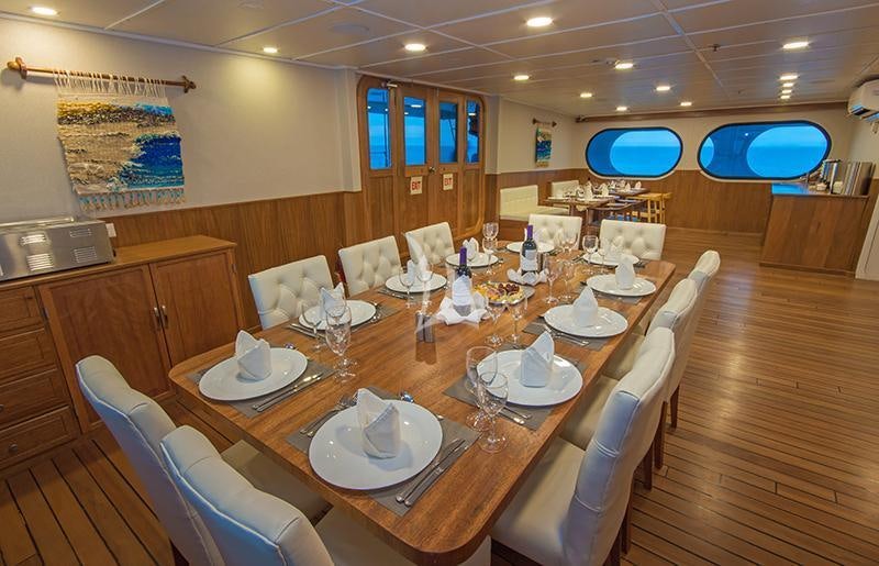 a large dining table with chairs aboard TIP TOP II Yacht for Charter