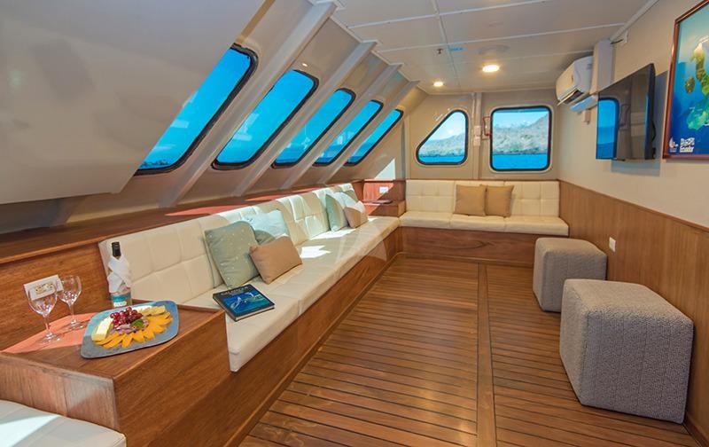 a room with a couch and a table and a television aboard TIP TOP II Yacht for Charter